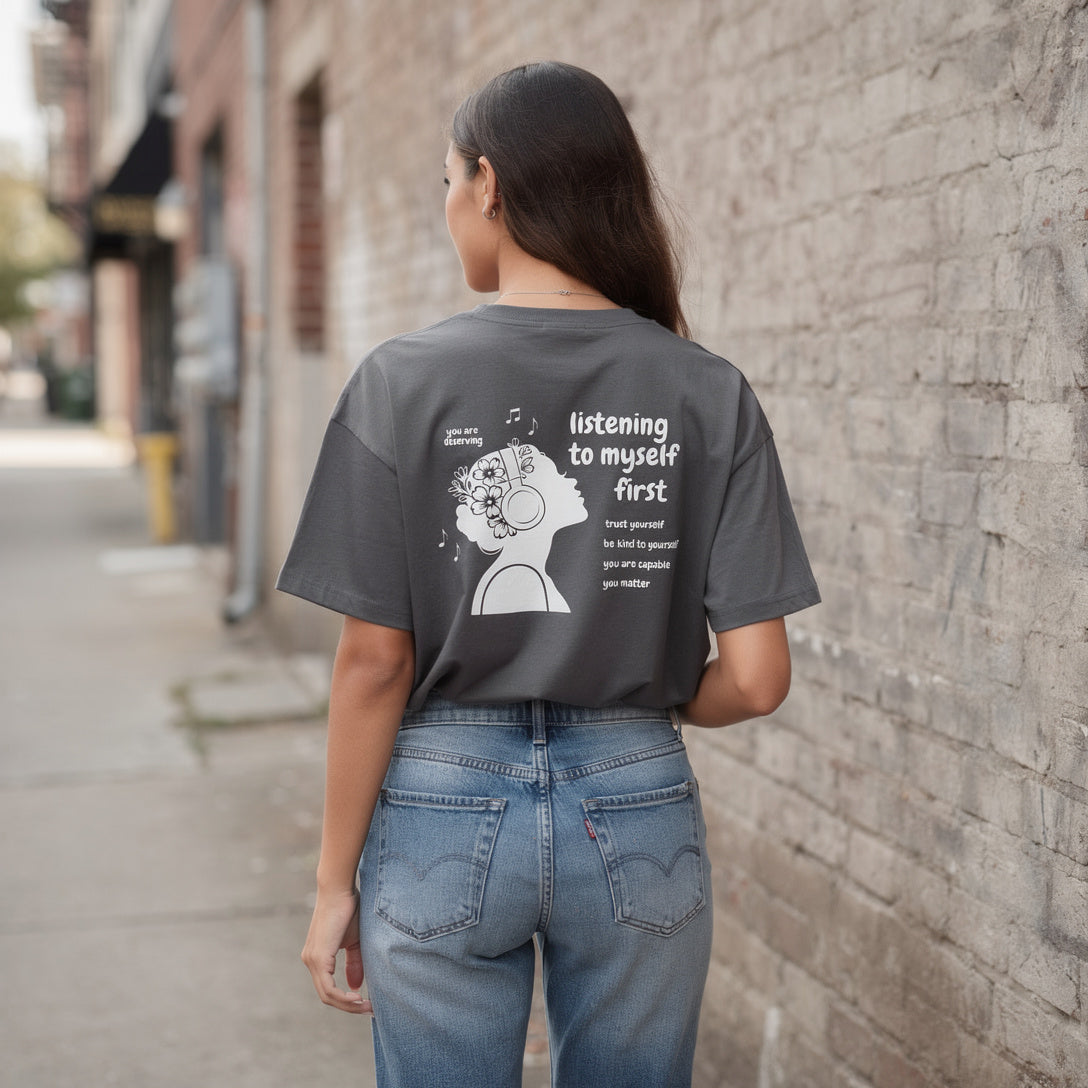 Model wearing Listening to Myself First Tee, Dark Gray. 